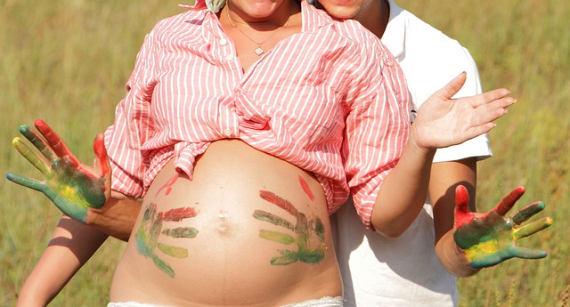 Pregnant woman with colorful handprints on her belly